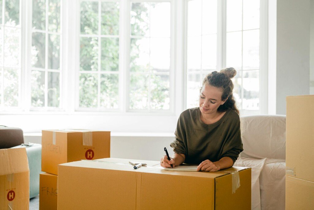 a woman packing her things and making a checklist for moving abroad